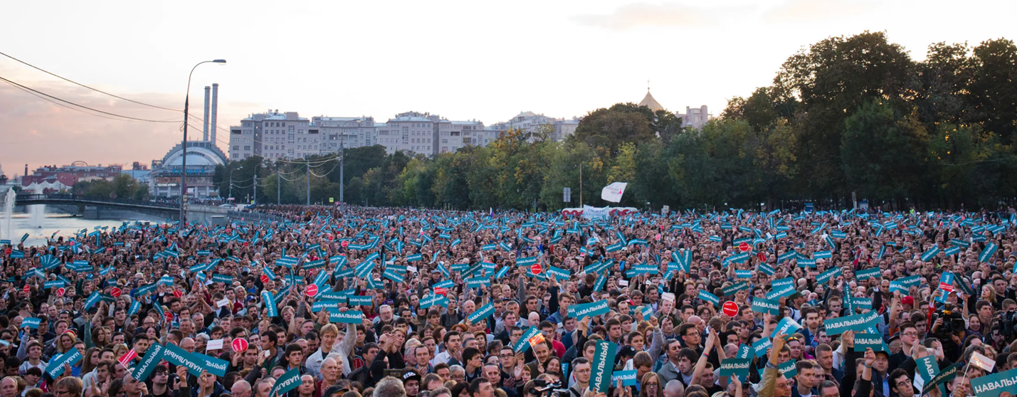 A large crowd of people holding signs
Description automatically generated