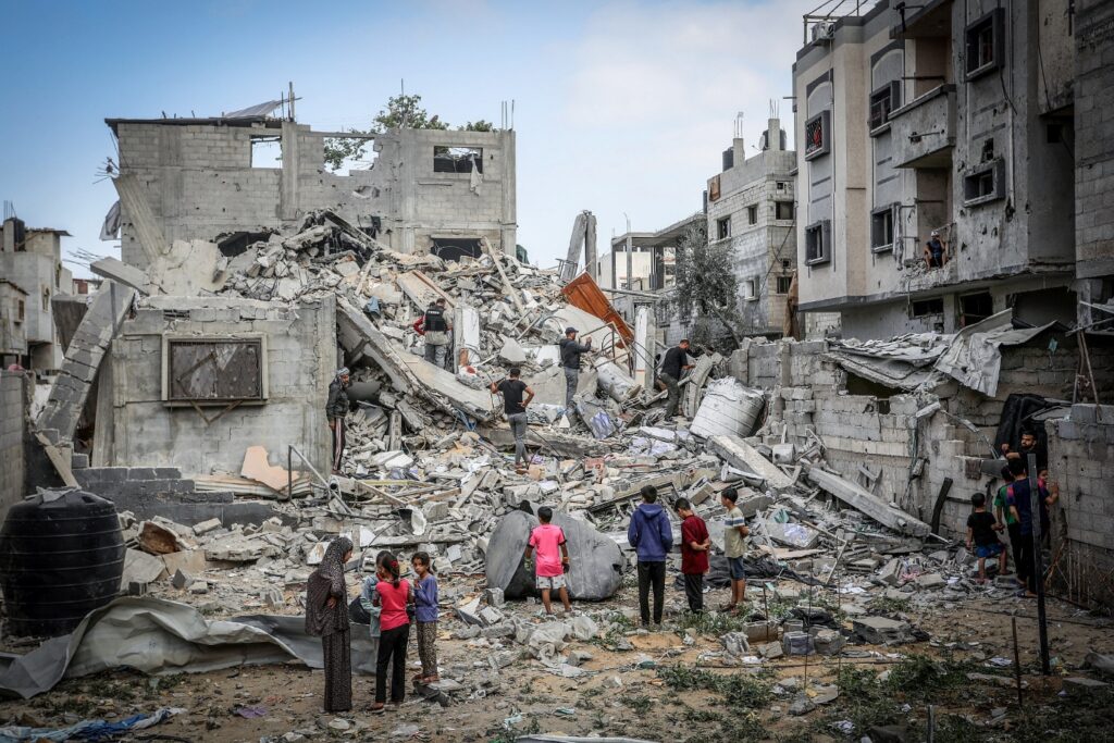 Filistinliler, Gazze Şeridi'nin güneyindeki Refah kentinde İsrail hava saldırısında yıkılan El Hatib ailesine ait evin yıkılışını inceliyor, 29 Nisan 2024 (Abed Rahim Khatib/Flash90)